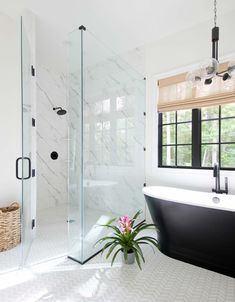 a bathroom with a bathtub, sink and window in the corner next to a potted plant