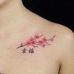 a woman's chest with pink flowers and chinese characters on it, in front of her