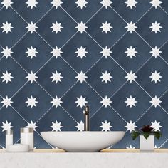 a bathroom sink sitting under a mirror next to a wall with white stars on it