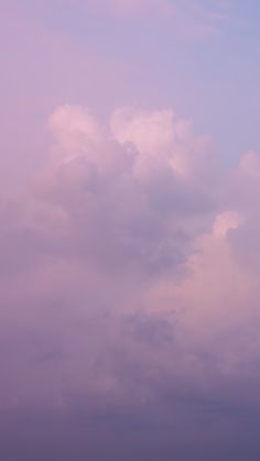 the sky is filled with clouds and there are two planes flying in the same direction