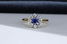 a blue and white diamond ring sitting on top of a table