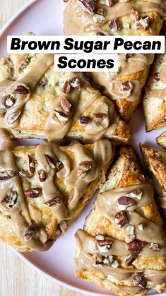 a white plate topped with scones covered in frosting and pecans on top of a wooden table