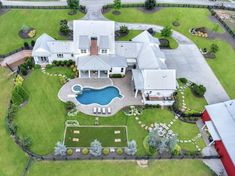 an aerial view of a large house with a pool in the yard and lots of grass