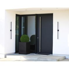 a black door is open on a white building