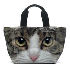 a close up of a cat's face on a tote bag with black handles