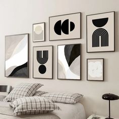 a bedroom with white walls and black and white art on the wall above the bed