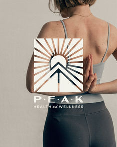 a woman with her back to the camera holding up a piece of paper that says peak health and wellness