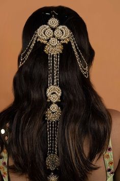 the back of a woman's head wearing a gold and crystal beaded headpiece