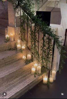 candles are lined up on the steps with greenery