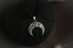 Lunula pendant with real moon texture. Price is listed per 1 item. Pendant without chain, the rubber cord in the set. Also, you can order this lunula pendant in a bronze:https://www.etsy.com/listing/745597208✪ MATERIALS: sterling silver, gemstone✪ DIMENSIONS: 1.18”/ 3 cm✪ CORD LENGTH: 13-15”/ 35-40 cm + extension chain✪ CUSTOM ORDER INFO: - Contact me personally for custom orders. - All the items are fully handmade and it takes some time to make them. Please visit for timing info: https://goo.gl Spiritual Moon Charm Pendant Jewelry, Hand Forged Spiritual Jewelry For Larp, Festival Moon Phase Round Pendant Jewelry, Adjustable Mystical Pendant Jewelry, Bohemian Crescent Jewelry Oxidized Finish, Bohemian Crescent Jewelry With Oxidized Finish, Moon Shaped Sterling Silver Festival Jewelry, Spiritual Crescent Engraved Jewelry, Sterling Silver Moon-shaped Festival Jewelry