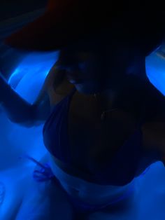 a woman sitting in a bathtub with blue light