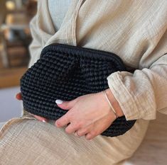 a woman is sitting down holding her purse