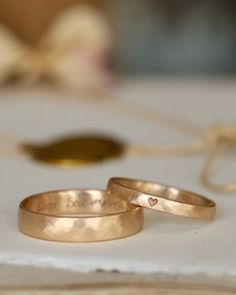 two wedding rings sitting on top of a table