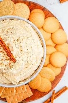 a white bowl filled with cinnamon dip surrounded by crackers