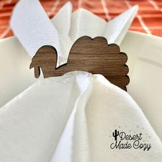 the napkin holder is made from wood and has a squirrel design on it, along with an orange table cloth