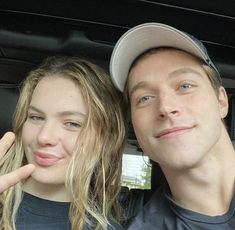 a man and woman sitting in the back seat of a car posing for a photo