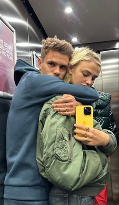 a man and woman hugging each other in an elevator