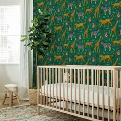 a baby's crib in front of a green wallpaper with giraffes and zebras