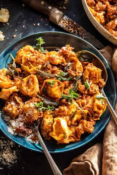 a blue plate topped with pasta covered in sauce