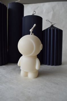 a small plastic toy sitting in front of three black vases