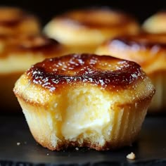 some kind of pastry sitting on top of a black surface with other pastries in the background