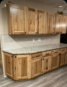 an empty kitchen with wooden cabinets and granite counter tops in the middle of the room