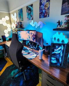 a desk with two computer monitors on top of it next to a chair and other items