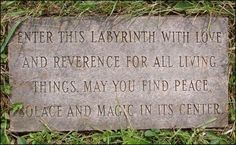 a memorial stone in the grass that says, enter this labrinth with love and reference for all living things may you find peace and magic in its center