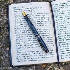 an open notebook with writing on it next to a fountain pen