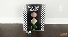 a traffic light that is sitting on the floor in front of a box with balls around it