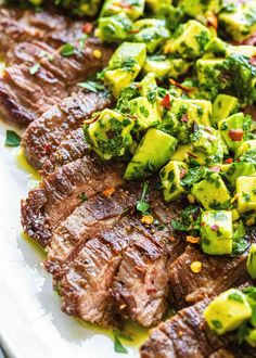 steak with broccoli and cucumbers on a white platter, ready to be eaten