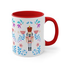 a red and white coffee mug with an image of a nutcracker on it