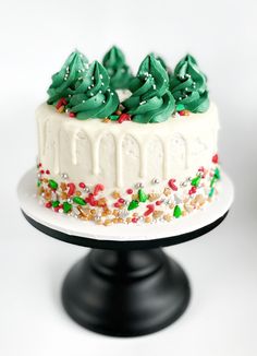 If you love dressing your Christmas Treeyou're going to love making this Christmas DIY cake kitDescription 'Winter PineDIY Cake KitDress this cake like you would dress your xmas treeSprinkle it in a bit of dazzleForest green buttercream perfect for making a delicious Xmas tree toppingA drizzling of white chocolate drip for decadence and our custom Christmas sprinkle mix that has all the Christmas favouritesThis cake is super easy to whip up and will definitely impress your family Cake With Trees On Top, Christmas Drip Cake Ideas, Diy Christmas Cake Decorations, Christmas Cake Buttercream, Christmas Cakes Decoration, Christmas In July Cake, Christmas Cake Decoration Ideas, Simple Christmas Cakes, Christmas Smash Cake