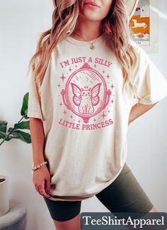 I'm Just A Silly Little Princess Shirt, Meme Shirt, Cat Lover Gift, Funny Cat Shirt, Cat T-shirt, Funny Sayings Shirt, Meme Graphic Tees, 90s Graphic Shirt Sizing and Color Information:  Our shirts are made to order specially for you. For this reason, we don't accept returns or exchanges. To ensure the perfect fit, please refer to our color and size charts before placing your order. If you have any questions, don't hesitate to send us a message to clarify sizing or colors. HOW TO ORDER MULTIPLES: 1. Select your size and color in the drop down menus & add to cart! 2. Then simply go back and repeat for each shirt. If you want to add or change anything on the existing design that we show in the display picture, please contact with us. Product Information: (T-shirts and Long Sleeve T-shirts) S Crew Neck Cotton Shirt With Cat Design, Cotton Crew Neck Shirt With Cat Design, Funny Cotton Tops With Cat Design, Funny Princess, Princess Shirt, Cat Lover Gift, Cat T Shirt, Cat Shirt, Funny Sayings