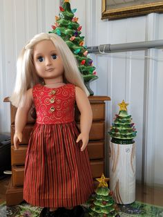 a doll standing next to a christmas tree