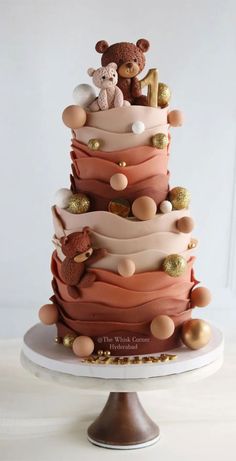 a three tiered cake decorated with teddy bears and other decorations on top of it