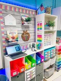 a laptop computer sitting on top of a desk next to colorful bins and baskets