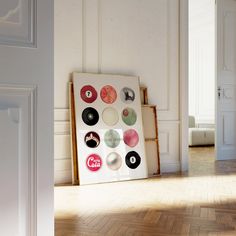 a white room with a wooden floor and an art piece on the wall next to it