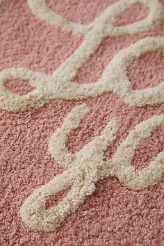 a pink rug with white letters on it