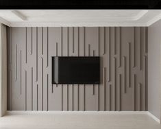 an empty room with a television mounted on the wall and vertical lines painted on the wall