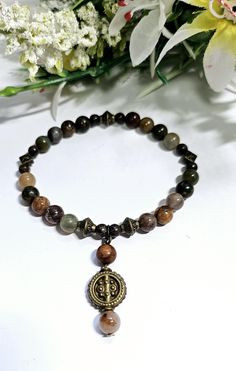 This is a beautiful brown gemstone and Bronze bracelet. It is lovingly handmade to a high standard using 6mm genuine A grade Picasso Jasper and Indian Agate gemstones,  alongside 4mm Snowflake Obsidan beads that are highlighted with antique bronze tibetan style beads and finished off with a beautiful dangling charm which dangles from the bracelet beautifully with an antique bronze bead. Agate cleanses and stabilises the aura, eliminating and transforming negativity. Agate enhances mental functio Brown Gemstone Beads Bracelets For Meditation, Brown Beaded Bracelets With Natural Stones, Spiritual Brown Beaded Bracelets With Gemstone Beads, Spiritual Brown Gemstone Beaded Bracelets, Brown Gemstone Beads Bracelets For Jewelry Making, Brown Gemstone Beads For Jewelry Making, Brown Gemstone Beaded Bracelets, Brown Beaded Bracelets For Jewelry Making, Earthy Brown Beaded Bracelets With Gemstone Beads