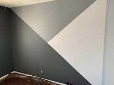 an empty room painted in grey and white with some paint on the wall next to it