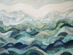 a quilted wall hanging with waves in the sky and water on it's sides