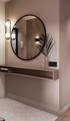 a round mirror hanging on the wall above a wooden table with a plant in it