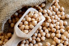 a bag filled with chickpeas next to a wooden spoon