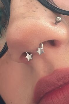 a close up of a person with some piercings on their nose