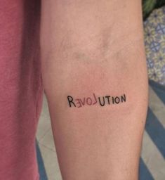 a person with a tattoo on their arm that says revolution written in black ink next to the word revolution