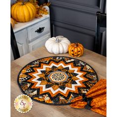 a table with pumpkins and other decorations on it, along with a decorative door mat