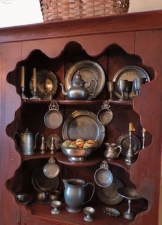 an old china cabinet with many pots and pans on it