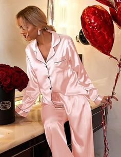 Experience the fusion of elegance with our satin pajama set. Designed for those who seek a graceful yet comfortable garment for their night-time ritual or casual day wear, this set is a versatile addition to any wardrobe. Product Features: Material Excellence: This set is made with high-grade satin, offering a breathable-and lightweight experience, and ensuring tranquil rest. Versatile Top: The pajama top is styled to transition seamlessly from a sleepwear piece to a chic casual outfit when pair Elegant Satin Sleepwear For Pajama Party, Feminine Satin Sleepwear Sets, Elegant Satin Sleepwear For Sleepover, Elegant Satin Sets For Home, Feminine Satin Sleepwear For Home, Feminine Satin Sleepwear, Elegant Satin Sets For Pajama Party, Pink Satin Home Sets, Satin Long Sleeve Bedtime Sets